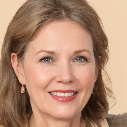 Joyful white adult female with medium  brown hair and grey eyes