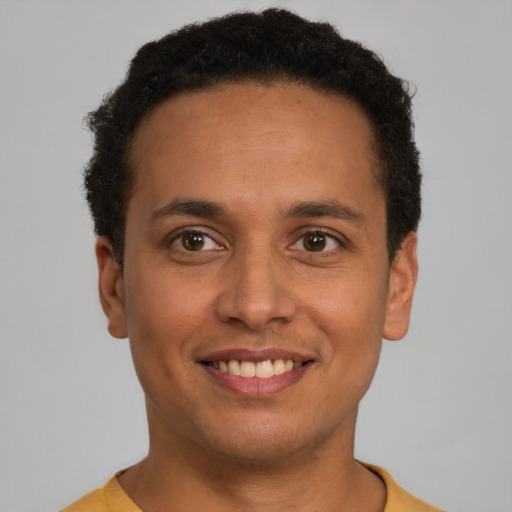 Joyful latino young-adult male with short  brown hair and brown eyes