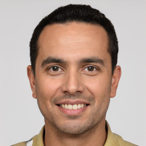 Joyful white young-adult male with short  black hair and brown eyes