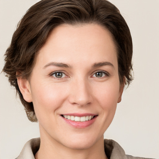 Joyful white young-adult female with short  brown hair and grey eyes