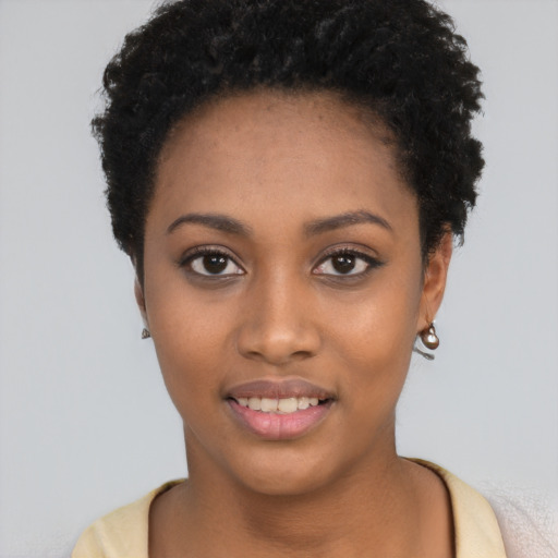 Joyful black young-adult female with short  black hair and brown eyes