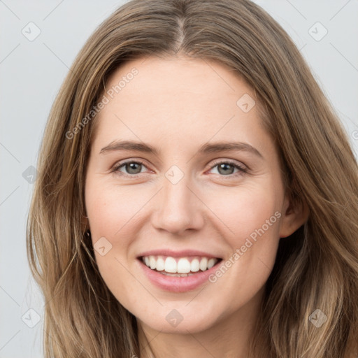 Joyful white young-adult female with long  brown hair and grey eyes