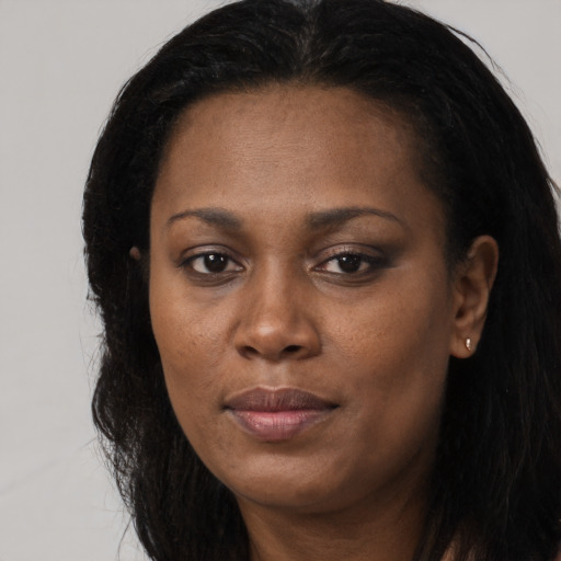 Joyful black young-adult female with long  black hair and brown eyes