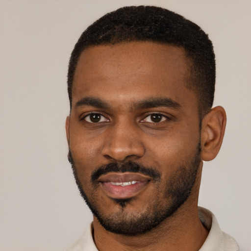 Joyful black young-adult male with short  black hair and brown eyes