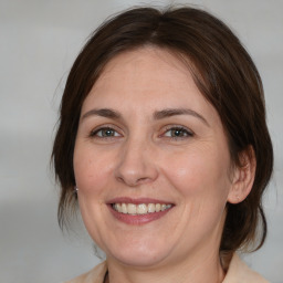 Joyful white adult female with medium  brown hair and brown eyes