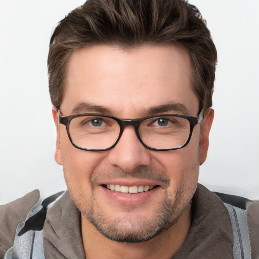 Joyful white young-adult male with short  brown hair and blue eyes