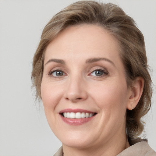 Joyful white adult female with medium  brown hair and grey eyes