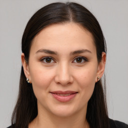 Joyful white young-adult female with long  brown hair and brown eyes