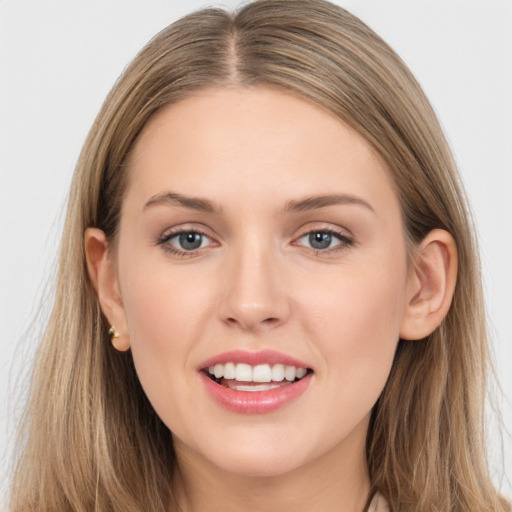 Joyful white young-adult female with long  brown hair and grey eyes