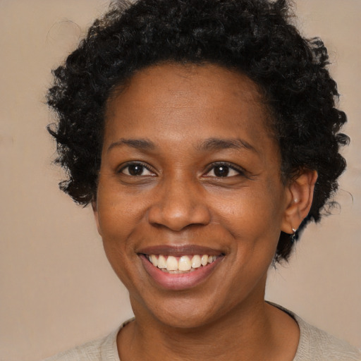 Joyful black adult female with short  brown hair and brown eyes