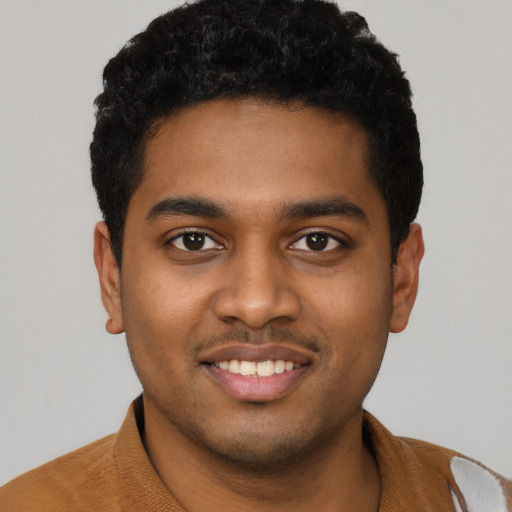 Joyful black young-adult male with short  black hair and brown eyes
