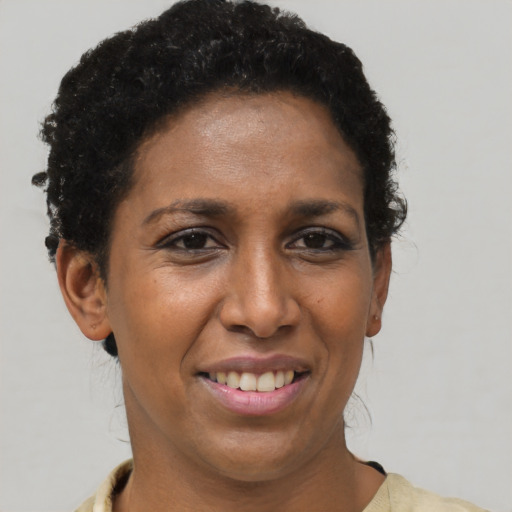 Joyful black adult female with short  brown hair and brown eyes