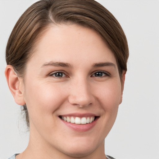 Joyful white young-adult female with short  brown hair and grey eyes