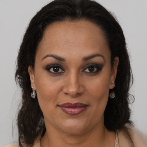 Joyful latino adult female with medium  brown hair and brown eyes