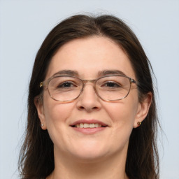 Joyful white adult female with long  brown hair and grey eyes