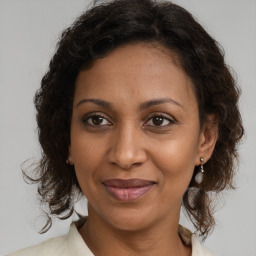 Joyful black adult female with medium  brown hair and brown eyes