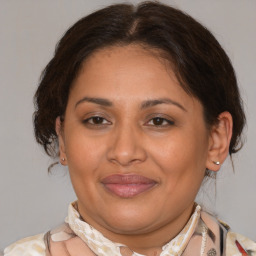 Joyful latino adult female with medium  brown hair and brown eyes