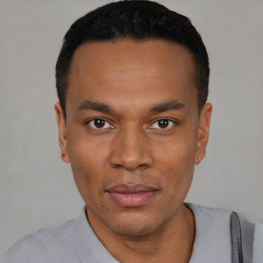 Joyful black young-adult male with short  black hair and brown eyes