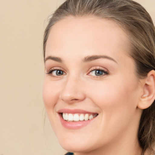 Joyful white young-adult female with medium  brown hair and green eyes