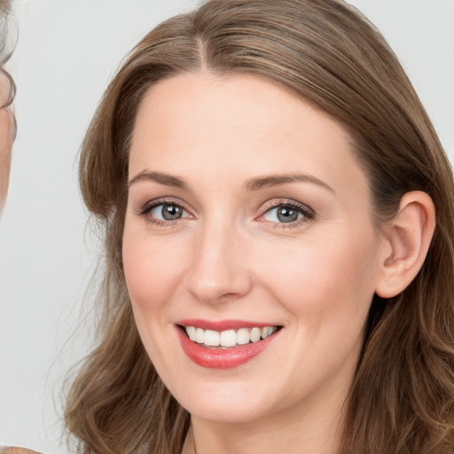 Joyful white young-adult female with long  brown hair and blue eyes