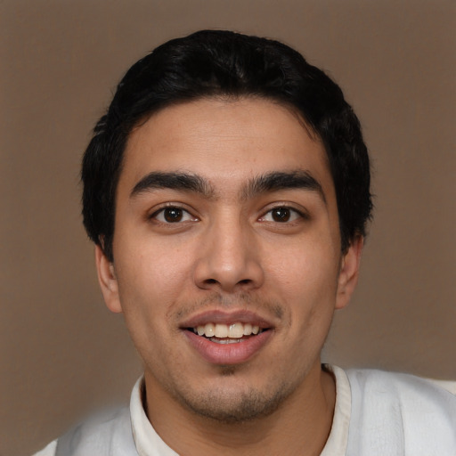 Joyful latino young-adult male with short  black hair and brown eyes
