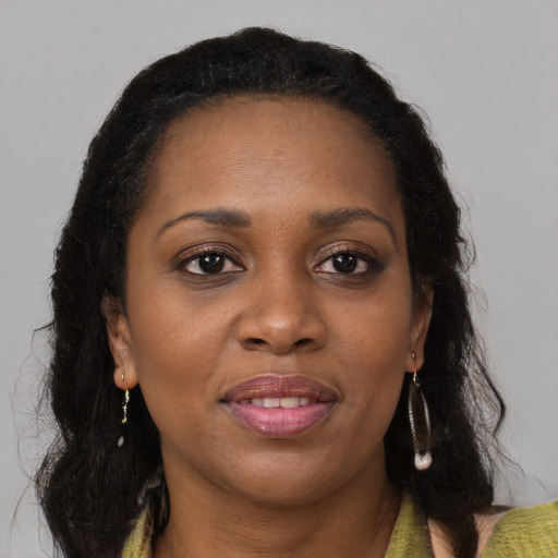 Joyful black young-adult female with long  brown hair and brown eyes