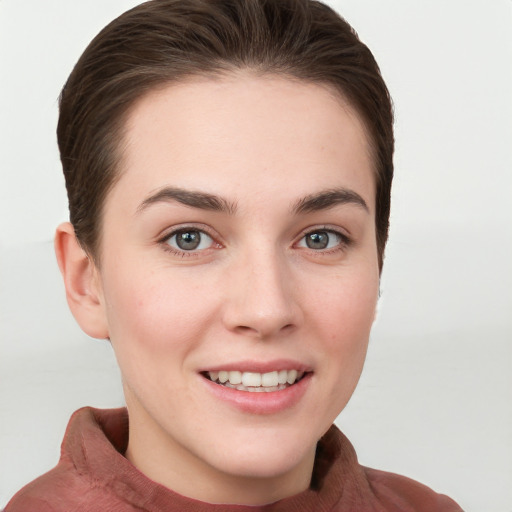 Joyful white young-adult female with short  brown hair and grey eyes