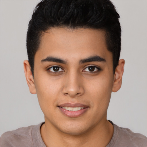 Joyful latino young-adult male with short  black hair and brown eyes