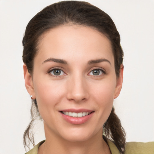 Joyful white young-adult female with medium  brown hair and grey eyes