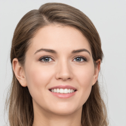 Joyful white young-adult female with long  brown hair and grey eyes