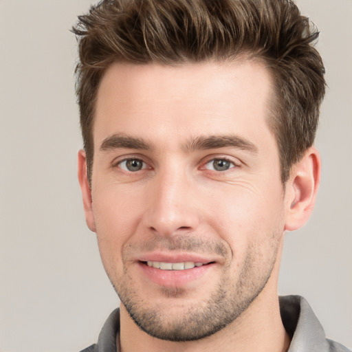 Joyful white young-adult male with short  brown hair and grey eyes