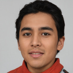 Joyful latino young-adult male with short  black hair and brown eyes