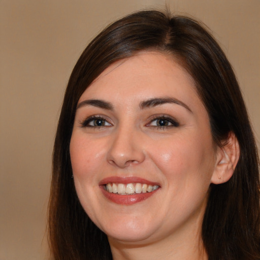 Joyful white young-adult female with long  brown hair and brown eyes