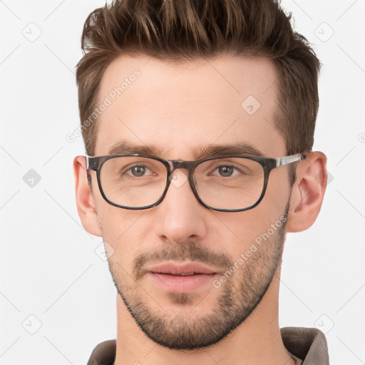 Joyful white young-adult male with short  brown hair and grey eyes