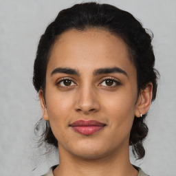 Joyful latino young-adult female with medium  black hair and brown eyes