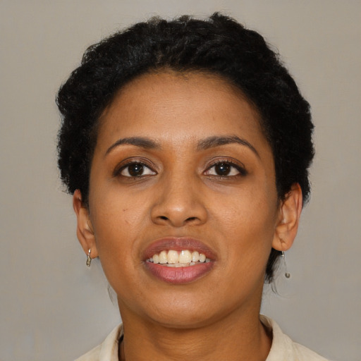 Joyful black young-adult female with short  black hair and brown eyes