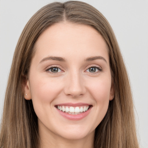 Joyful white young-adult female with long  brown hair and grey eyes