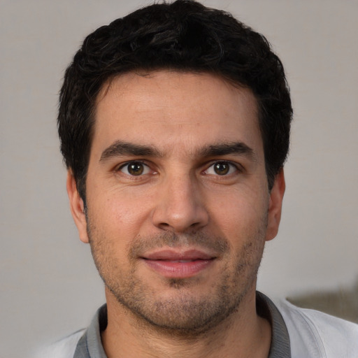 Joyful white young-adult male with short  black hair and brown eyes