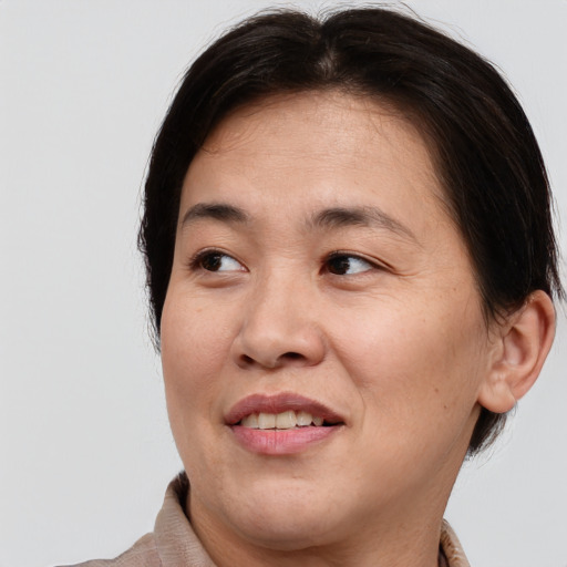 Joyful asian adult female with medium  brown hair and brown eyes