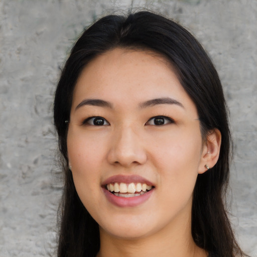 Joyful asian young-adult female with long  black hair and brown eyes