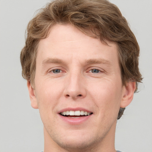 Joyful white adult male with short  brown hair and grey eyes