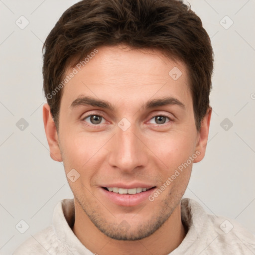 Joyful white young-adult male with short  brown hair and grey eyes