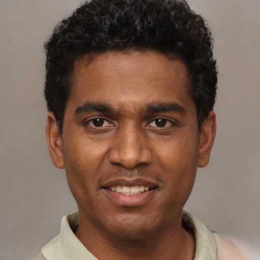 Joyful black young-adult male with short  black hair and brown eyes