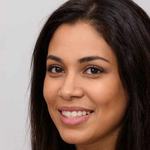 Joyful latino young-adult female with long  brown hair and brown eyes