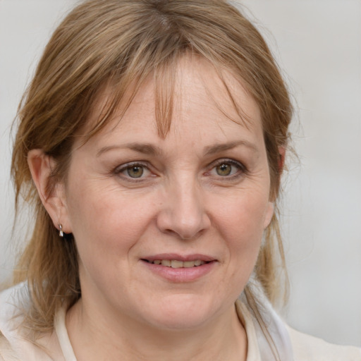 Joyful white adult female with medium  brown hair and blue eyes