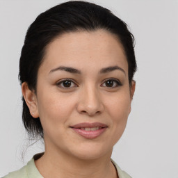 Joyful latino young-adult female with medium  brown hair and brown eyes