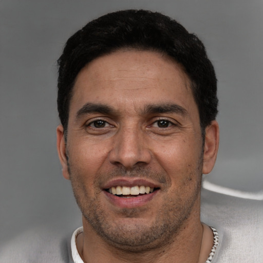 Joyful white young-adult male with short  black hair and brown eyes