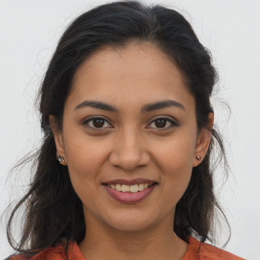 Joyful latino young-adult female with long  brown hair and brown eyes