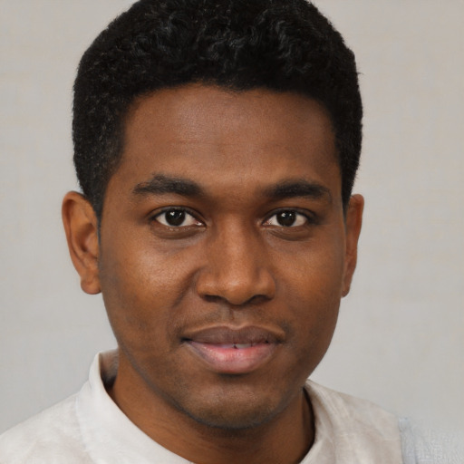 Joyful black young-adult male with short  black hair and brown eyes