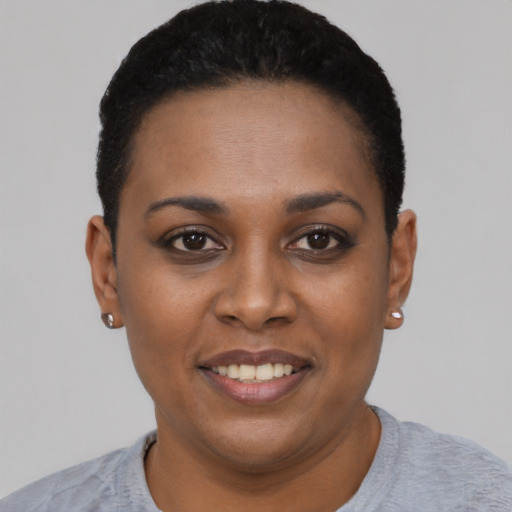 Joyful black young-adult female with short  black hair and brown eyes